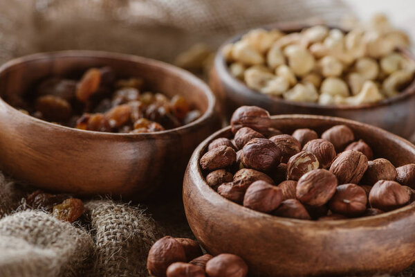 delicious nuts in wooden bowls on sackcloth background