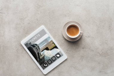 fincan kahve ve tablet bilet uygulaması ile üstten görünüm üstünde perde beton yüzeyi