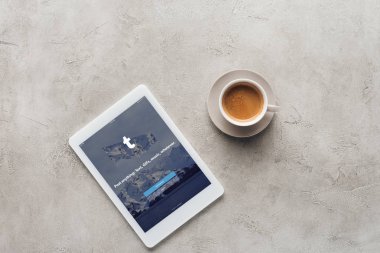 fincan kahve ve tablet tumblr app ile üstten görünüm üstünde perde beton yüzeyi