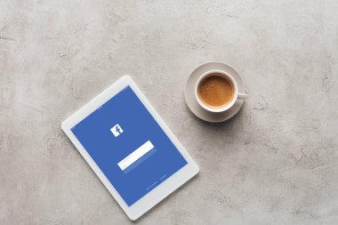 fincan kahve ve tablet facebook app ile üstten görünüm üstünde perde beton yüzeyi