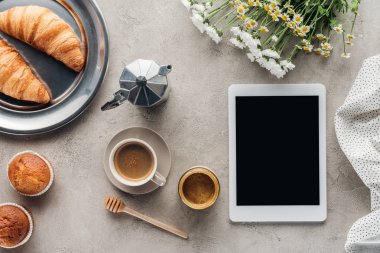 Beton yüzeyi pasta ile kahve ve tablet ile boş perde üstten görünüm