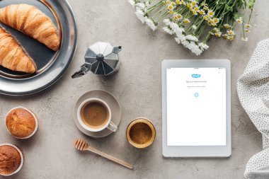 üstünde perde beton yüzeyi pasta ile kahve ve tablet skype uygulaması ile üstten görünüm