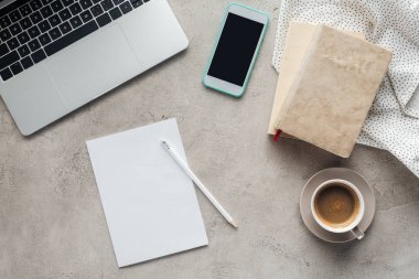 boş kağıt ile beton yüzeyinde dizüstü bilgisayar ile kahve ve smartphone ile boş perde üstten görünüm