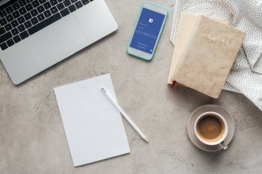 ekran boş kağıt ile beton yüzeyi Tarih dizüstü bilgisayar ile kahve ve smartphone ile facebook app üstten görünüm