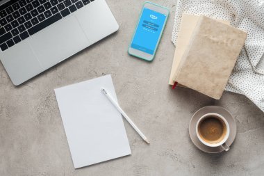 ekran boş kağıt ile beton yüzeyi Tarih dizüstü bilgisayar ile kahve ve smartphone skype uygulaması ile üstten görünüm