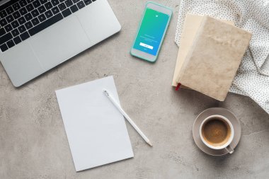 ekran boş kağıt ile beton yüzeyi Tarih dizüstü bilgisayar ile kahve ve smartphone twitter uygulaması ile üstten görünüm