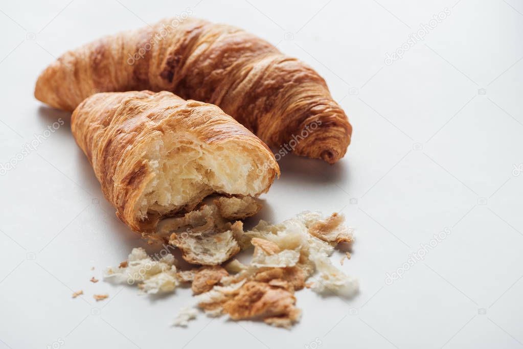 close-up shot of delicious bitten croissants on white surface