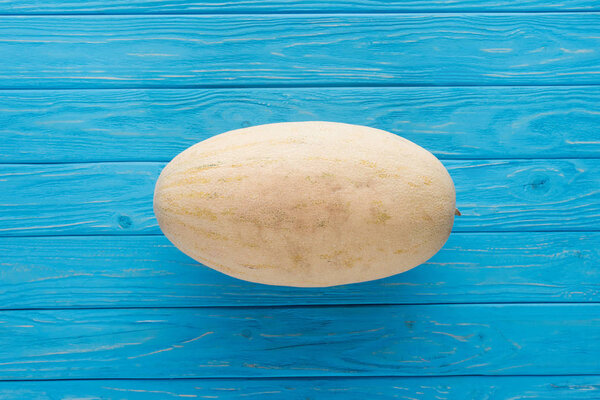 top view of whole ripe cantaloupe melon on blue wooden surface  
