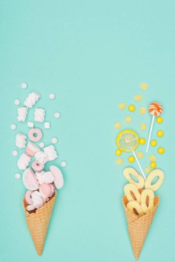 Marshmallow, lolipop ve turkuaz üzerinde izole gözleme koniler üstten görünüm