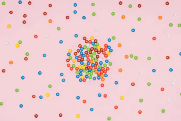 在粉红色的分散美味的糖衣杏仁下落糖果的高视图 — 图库照片