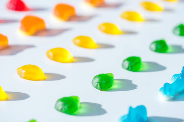 set of sweet yellow, green and blue jelly candies on white