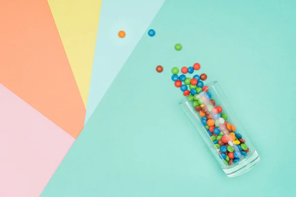 Draufsicht Auf Verstreute Süße Dragee Bonbons Und Glas Auf Farbiger — Stockfoto
