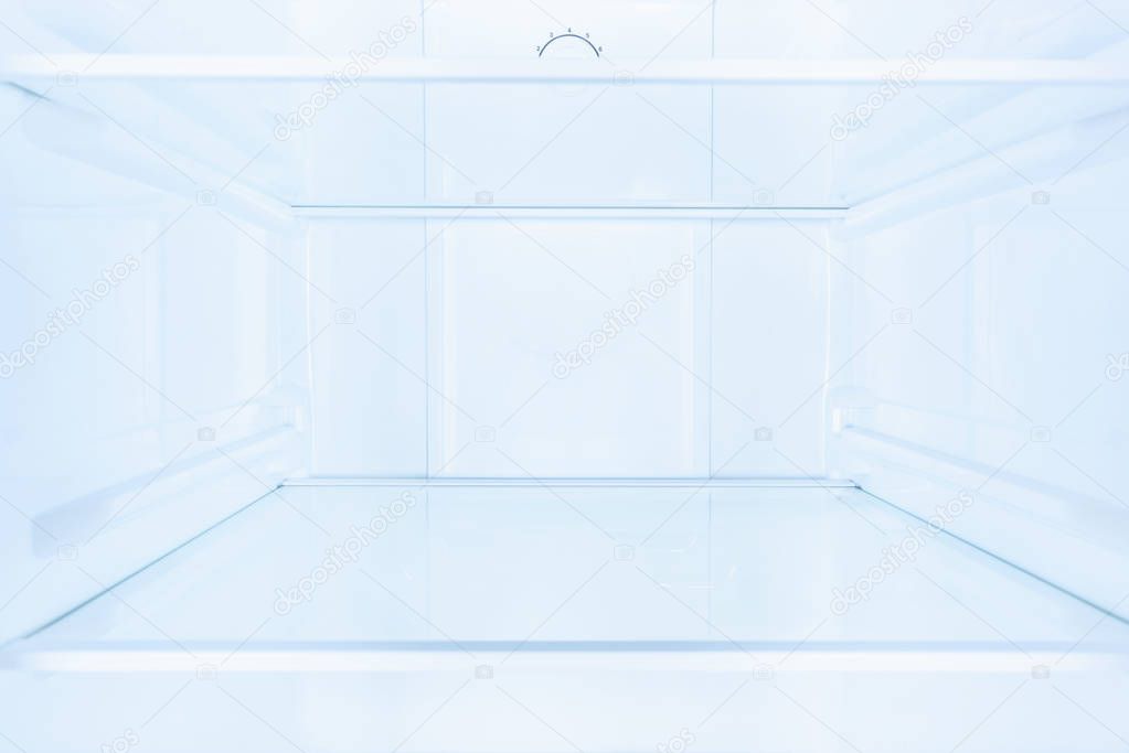 shelves in empty open white fridge