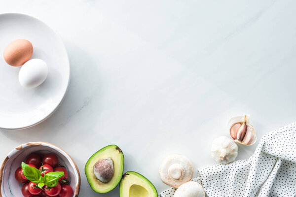 вид сверху на ингредиенты для приготовления омлета на завтрак на поверхности белого мрамора
