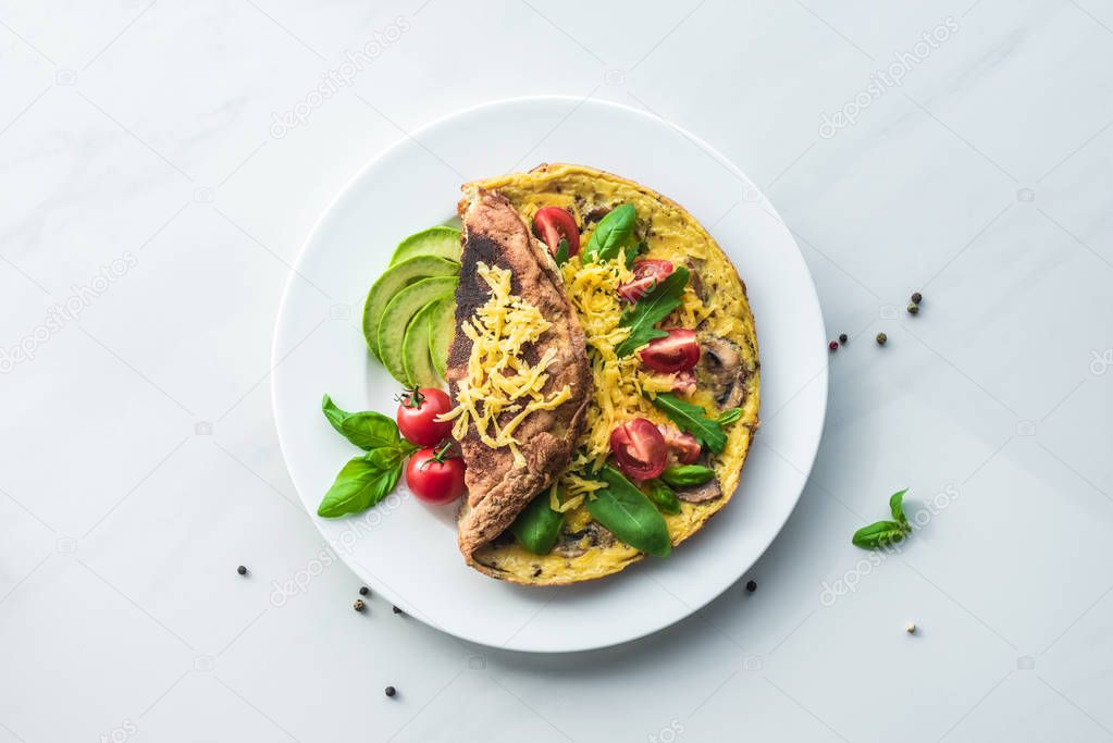 top view of healthy omelette for breakfast with vegetables on white marble surface