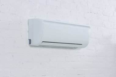 close-up shot of air conditioner hanging on brick wall clipart
