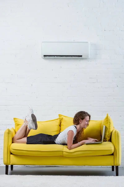 Happy Young Woman Working Laptop While Lying Couch Air Conditioner — Stock Photo, Image