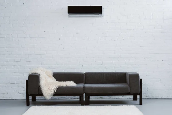 air conditioner hanging on white brick wall at living room