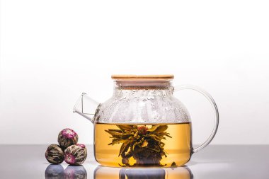 Çin çiçeklenme çay tabloda çay topları ile cam çaydanlık