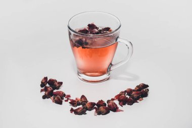 dried rose buds tea in cup on white tabletop
