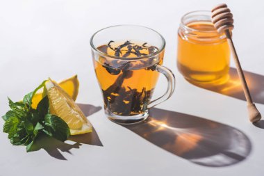 Tatlım, limon ve nane beyaz masa üzerinde sağlıklı siyah çay