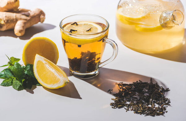 healthy black tea with lemon and mint on white tabletop