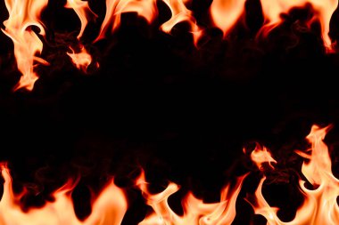 close up view of burning orange flame with blank space in middle on black background clipart