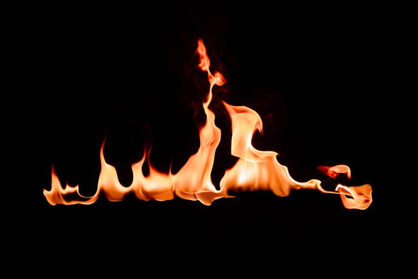 close up view of burning orange flame on black background