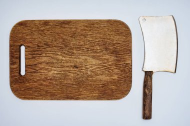 top view of wooden chopping board and meat knife isolated on grey clipart