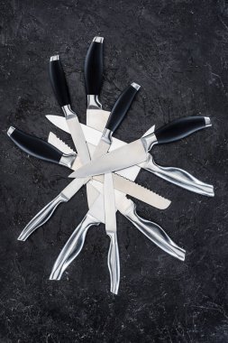 siyah yüzey üzerinde düzenlenen çeşitli mutfak bıçaklar üstten görünüm  