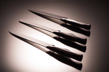 close-up view of various kitchen knives on grey clipart