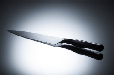 close-up view of single kitchen knife reflected on grey clipart
