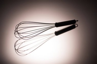 close-up view of single whisk with reflection on grey clipart