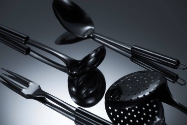 close-up view of shiny stainless steel utensils reflected on grey clipart