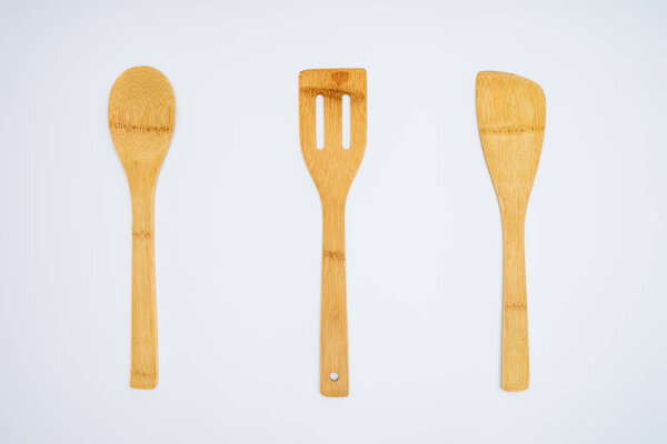 top view of arranged wooden kitchen utensils isolated on grey