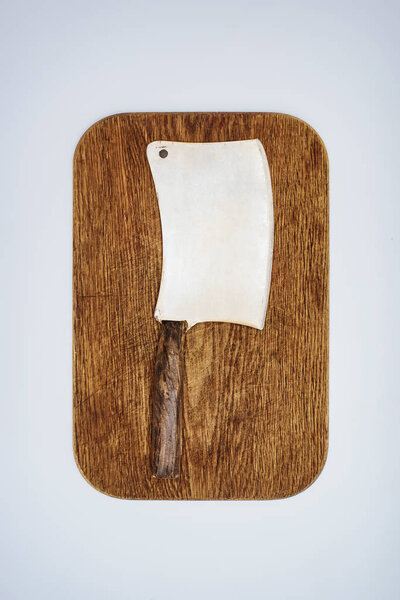 top view of meat knife on wooden chopping board isolated on grey 