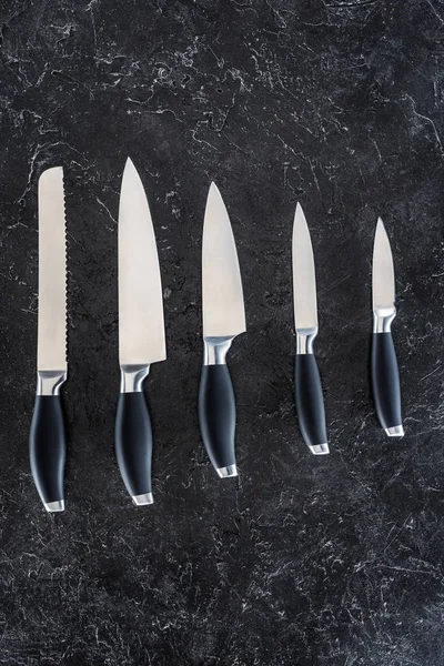 Κάτοψη Των Διαφόρων Μαχαίρια Κουζίνας Τοποθετημένα Μαύρο Μαρμάρινη Επιφάνεια — Δωρεάν Φωτογραφία