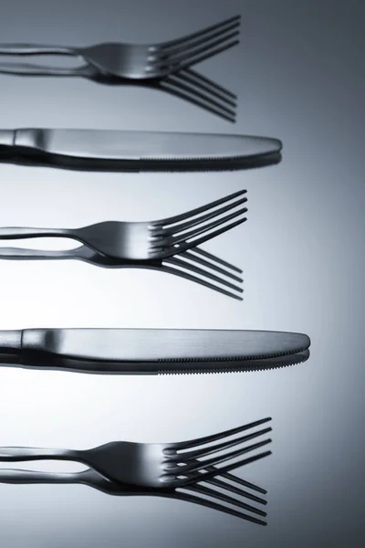 Close View Shiny Forks Knives Reflected Grey — Stock Photo, Image