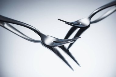 close-up view of shiny forks with two tines reflected on grey  clipart