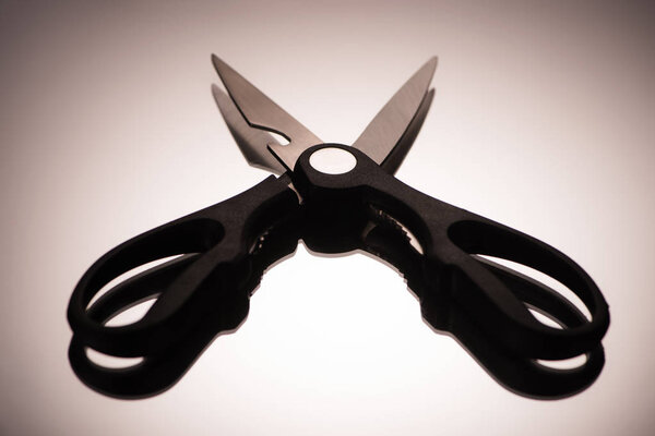 close-up view of professional kitchen scissors reflected on grey