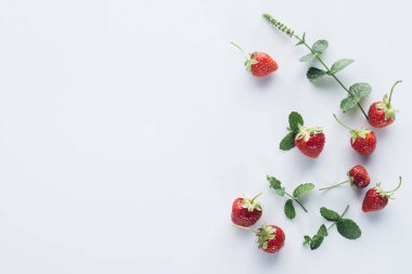 top view of fresh strawberries with mint leaves on white surface clipart