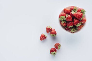 kase taze bütün çilek beyaz yüzey üzerinde yukarıdan