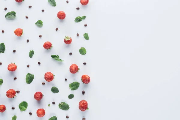 在白色表面的薄荷叶和咖啡豆的成熟草莓的顶级视图 — 图库照片
