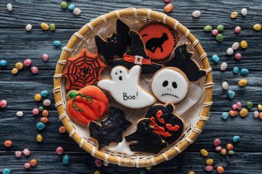 hasır sepet şeker ahşap masa üzerinde çevrili ev yapımı spooky halloween kurabiye ile üstten görünüm 