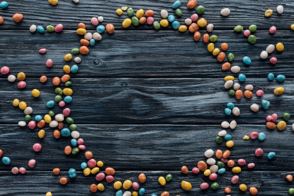 circle made of colorful delicious candies on wooden background  