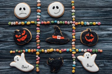elevated view of composition from colorful candies and arranged halloween cookies on wooden table  clipart