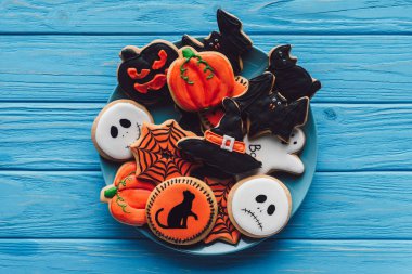 elevated view of plate with spooky homemade halloween cookies on wooden table  clipart