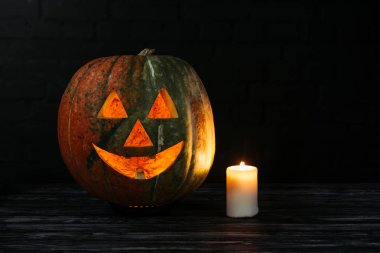 spooky halloween kabak siyah arka plan üzerine ahşap masa mum ile oyulmuş