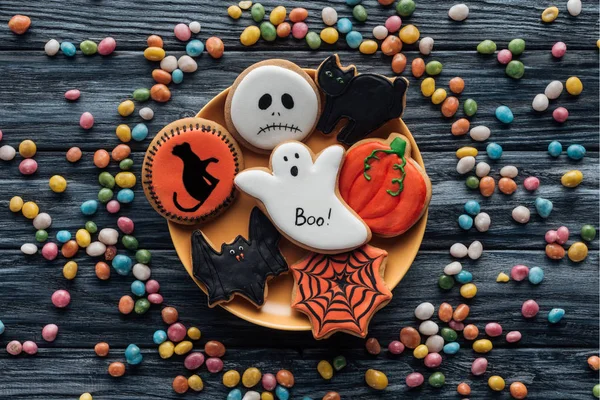 Top View Plate Halloween Cookies Surrounded Colorful Candies Wooden Table — Stock Photo, Image