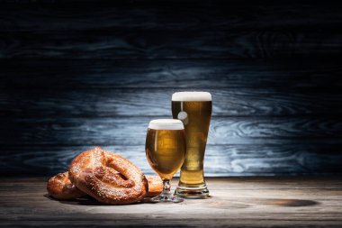 lezzetli bira ve ahşap masa, oktoberfest kavramı üzerinde nefis simit iki bardak